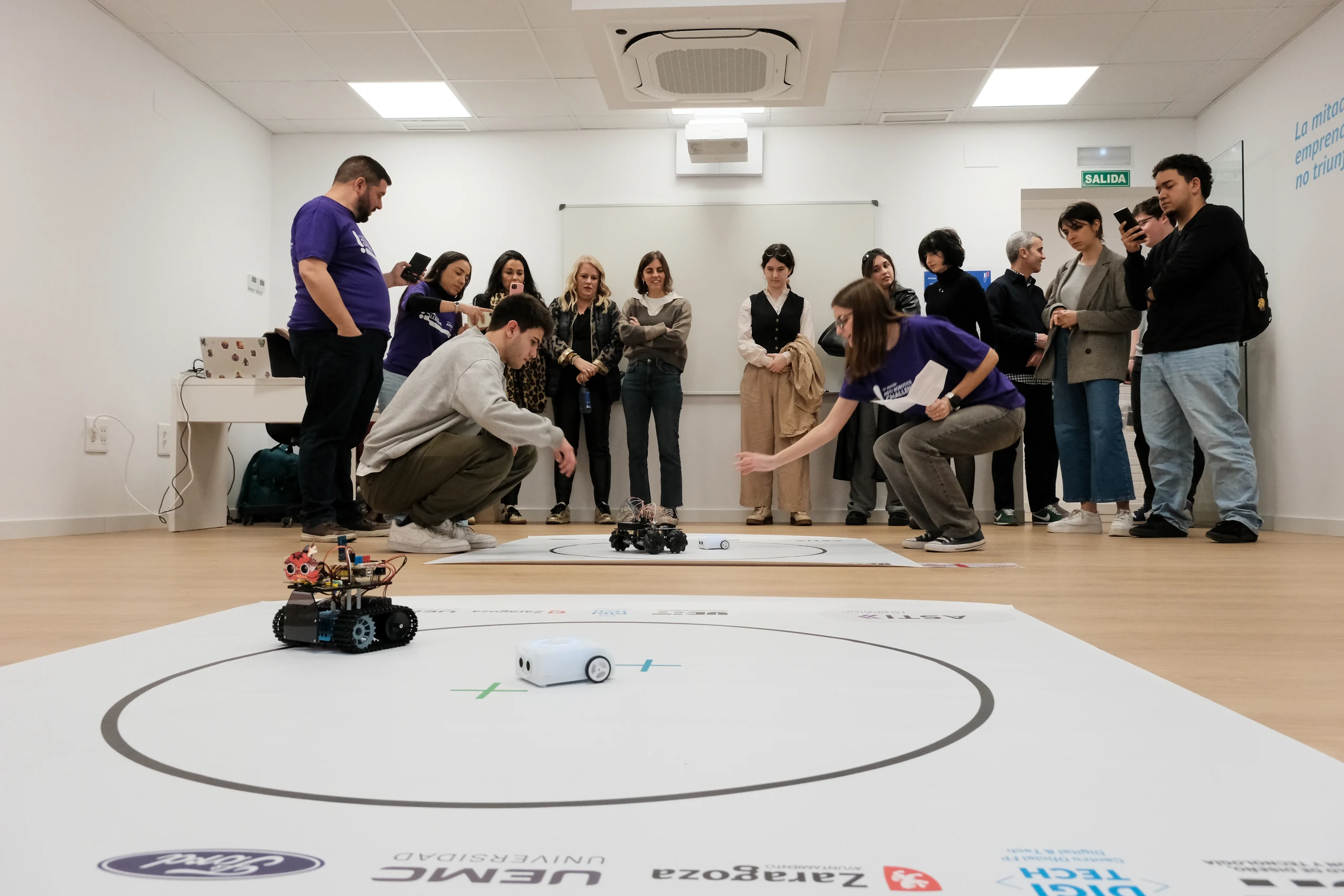 competicion-robots-en-tapete-circular-con-publico